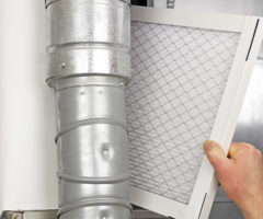 person replacing air conditioner or furnace filter